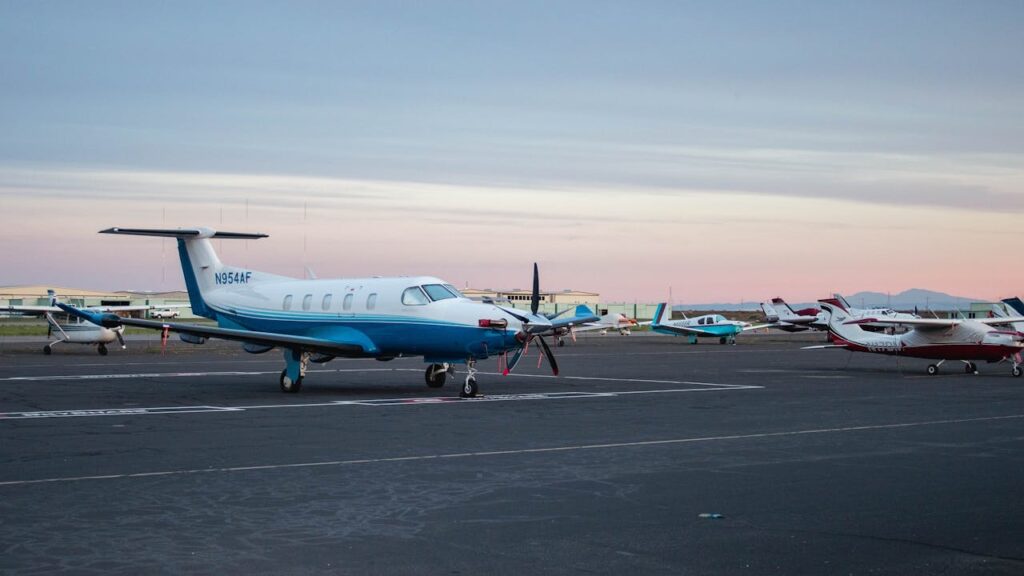 A serene view of private jets lined up on an airport runway during twilight.